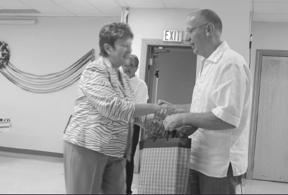 Vicki Karpiak presenting Ambassador Ihor Ostash one of many community parting gifts. Borys Sirskyj in background.