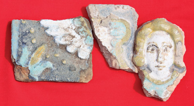 Fragments of a glazed tile (kakhlia), featuring an angel, from the stove facing in the palace. Excavations of 2009. Photo by V. Mezentsev.